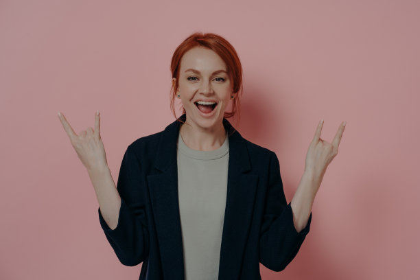 疯狂的红发欧洲女人，有犄角的迹象，摇滚的手势图片下载