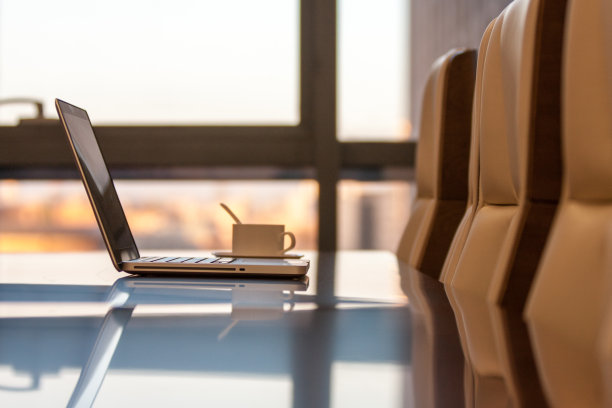 木制会议桌上放着笔记本电脑图片下载