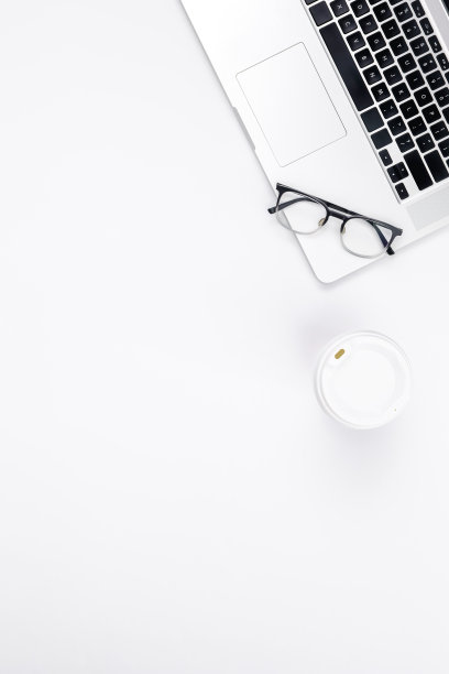 简约的白色背景与笔记本电脑，一次性纸杯和玻璃杯。图片下载