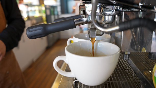 浓缩咖啡从咖啡机的两侧优雅地倒出的特写镜头。图片下载
