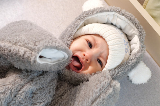 一位母亲在家里给她的小男孩穿衣服。童年为人父母和成长中家庭观念真实的人图片下载