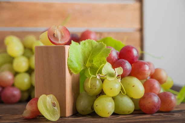 在木制背景上切下带籽的葡萄，特写和复制空间……图片下载