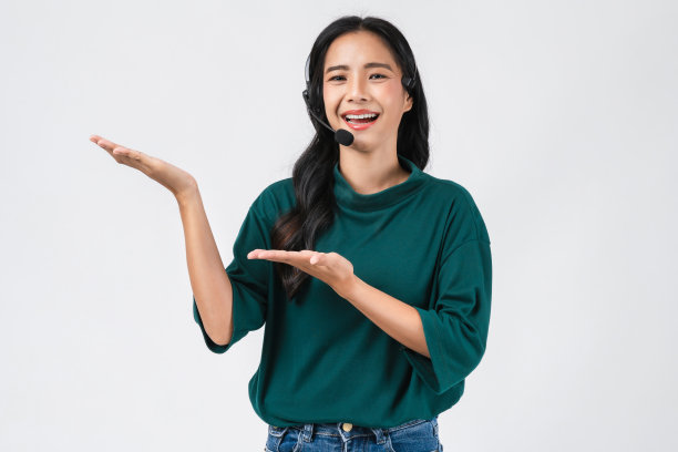 开朗美丽的亚洲女性顾问在工作场所戴着白色背景的客户支持电话接线员的麦克风耳机。图片下载