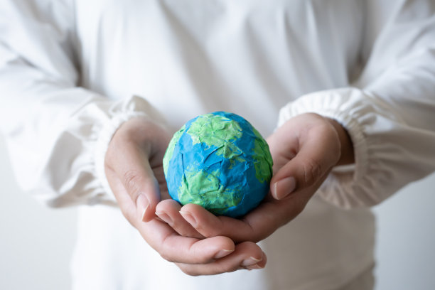 手里拿着土、纸和水颜料。保护世界免受全球变暖影响的理念图片下载