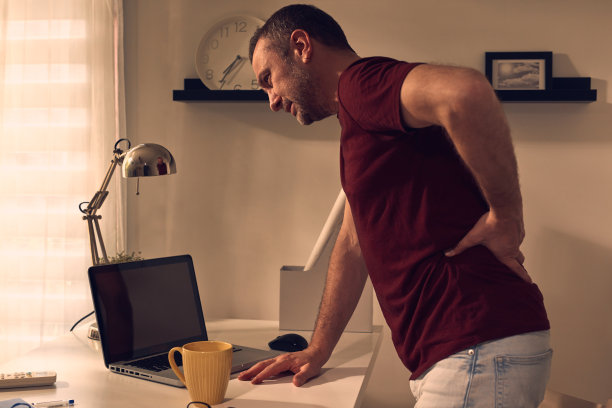 男人与臀部，背部，脊柱，疝和坐骨神经痛在家里。图片下载