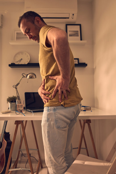男人与臀部，背部，脊柱，疝和坐骨神经痛在家里。图片下载