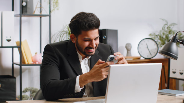 商人被智能手机上的突然胜利、游戏中奖、彩票目标实现的好消息震惊了图片下载