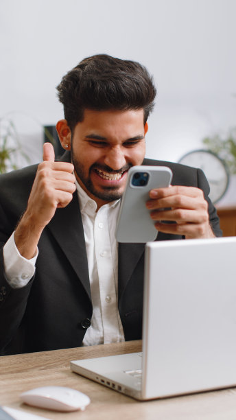 商人被智能手机上的突然胜利、游戏中奖、彩票目标实现的好消息震惊了图片下载