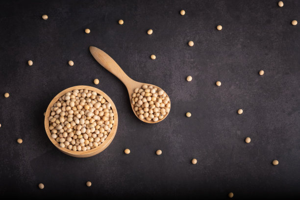 俯视图有机大豆在一个碗和勺子和黑色背景。蛋白质营养概念。图片下载