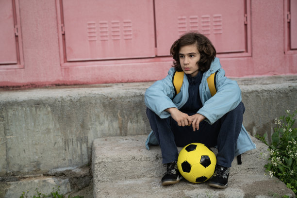 户外拿着足球的生病男孩照片图片下载