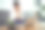 一名亚洲女性坐在家里的沙发上使用笔记本电脑，身体疼痛。图片下载