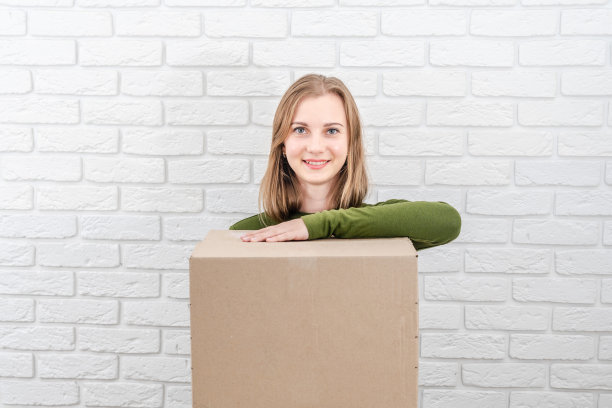 拿着包裹盒的年轻美女。投递包裹图片下载