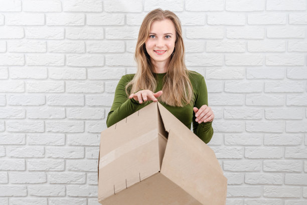 拿着包裹盒的美女。投递包裹图片下载