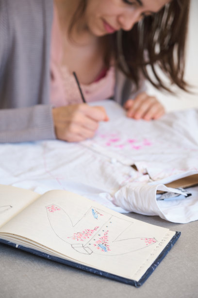 一个女人用丙烯颜料在衬衫上手绘图案的特写。图片下载
