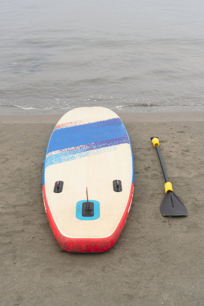 Sup Stand Up Paddle Board，桨在沙滩上，背景是大海图片下载