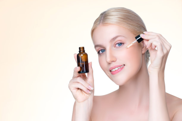 优雅美丽的女人拿着CBD油在孤立的背景。图片下载