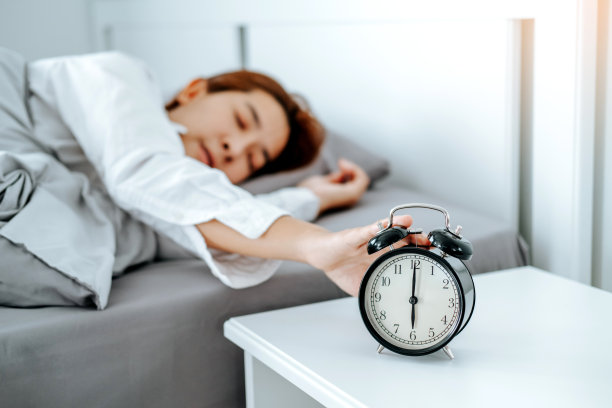 亚洲女人一大早醒来，被闹钟打扰图片下载