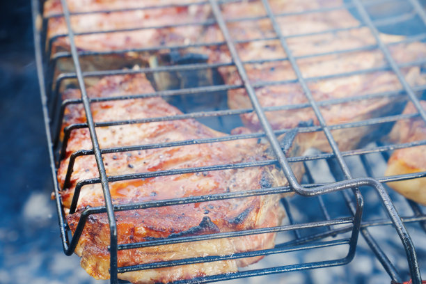 烤肉架上在明火上烤的肉排图片下载