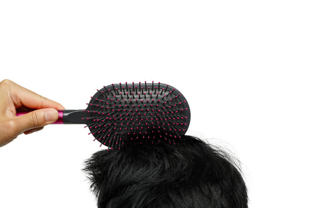 美发师用双手在白色背景上梳理英俊年轻人的头发。男士理发理念，干净健康的人发无毛图片下载