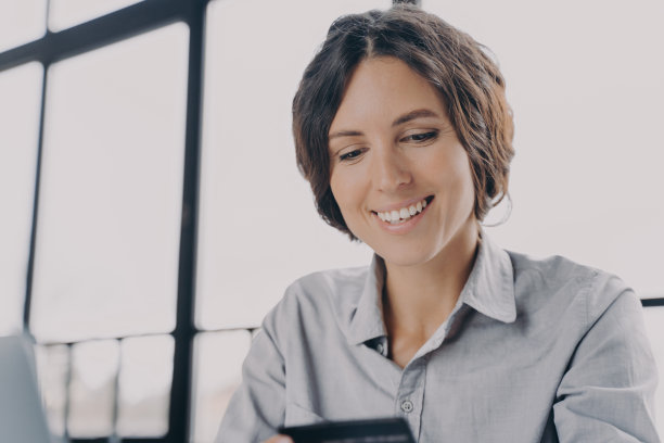 微笑的女商人用信用卡在工作中使用支付系统图片下载