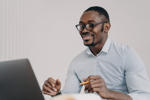 穿着正装的快乐年轻商人与客户或同事进行视频聊天。图片下载