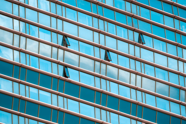 窗户开着的现代建筑的外部。建筑的背景。建筑立面的碎片，带有绿色和透明的玻璃。图片下载