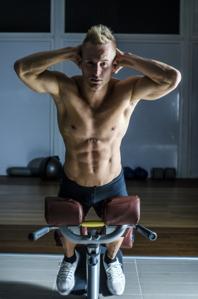 有魅力和健康的年轻人在健身房锻炼腿图片下载