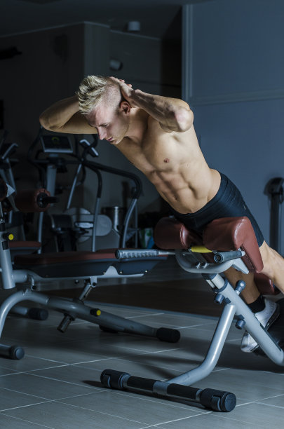 有魅力和健康的年轻人在健身房锻炼腿图片下载