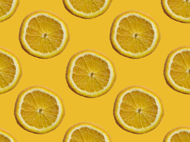 在黄色背景上的橙片无缝图案。图片下载
