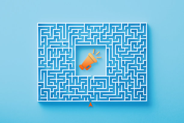 橙色的扩音器符号位于蓝色背景的白色迷宫的中心图片下载