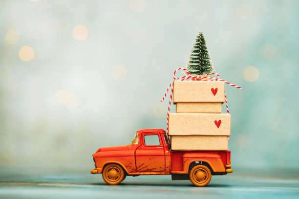 红色的小卡车上有一堆圣诞礼物和圣诞树图片下载