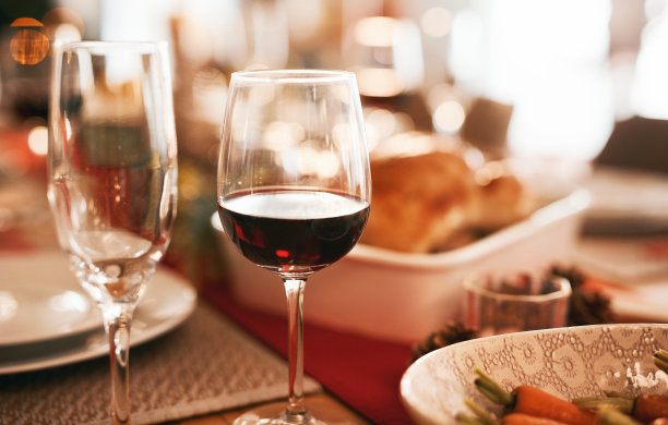 圣诞节，食物和节日庆祝与酒，杯子和盘子在餐桌上和设置在家里。节日，传统和美味的自制午餐或晚餐聚会图片下载
