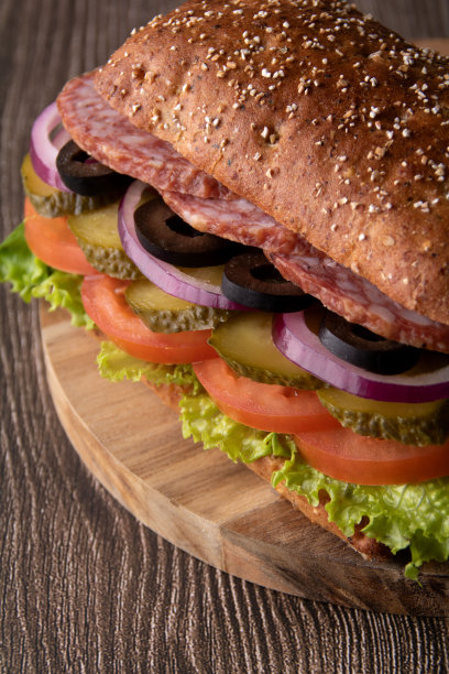 在木板上拍摄香肠和蔬菜三明治图片下载