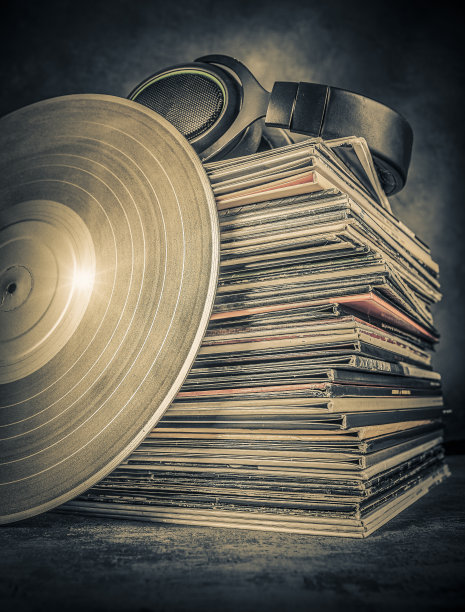 黑胶唱片和耳机在灰色背景。音乐的概念。副本的空间。图片下载