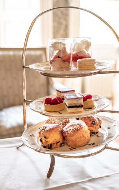 一个蛋糕摊，摆满了美味的烤饼、蛋糕和其他美味的食物，这是一个庄严的英国下午的一部分。图片下载