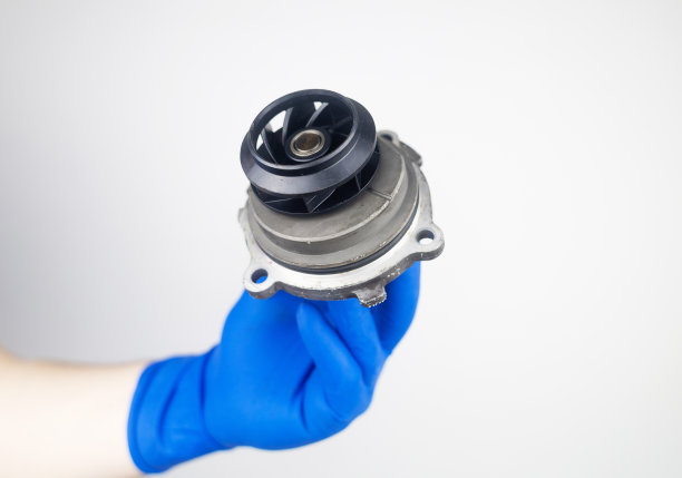 正时皮带破裂。更换故障的发动机传动带。橡胶裂缝和电线断裂的危险。按规定更换设备。戴蓝手套的技工图片下载