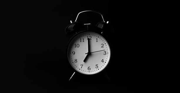 黑色闹钟黑色背景。图片下载
