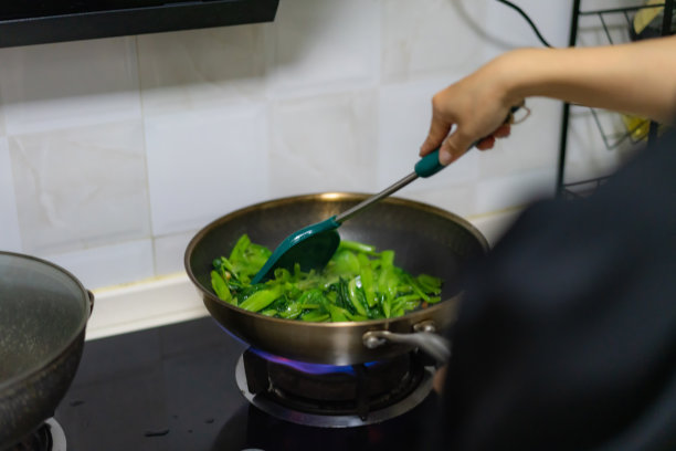 妇女用天然气炒菜图片下载