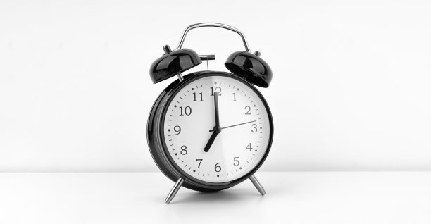 白色墙壁背景上的黑色闹钟图片下载
