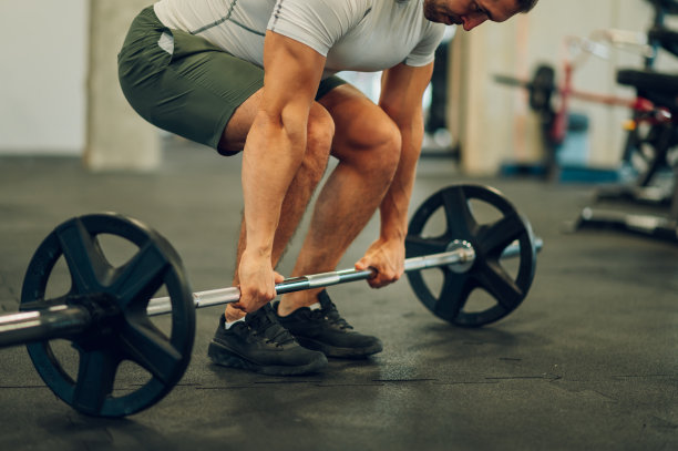 一位肌肉运动员正在健身房做硬举。图片下载