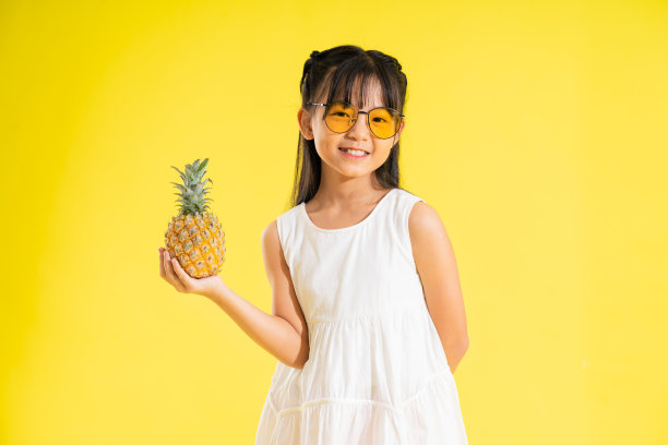 黄色背景上快乐微笑的亚洲女婴图片下载