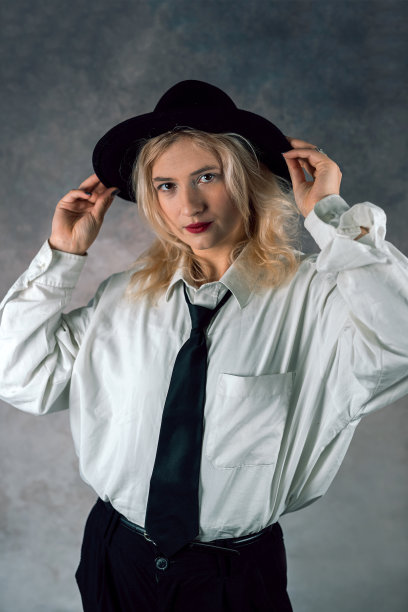 美丽的时尚模特在朴素的背景上穿着宽松的裤装。女人的时尚图片下载