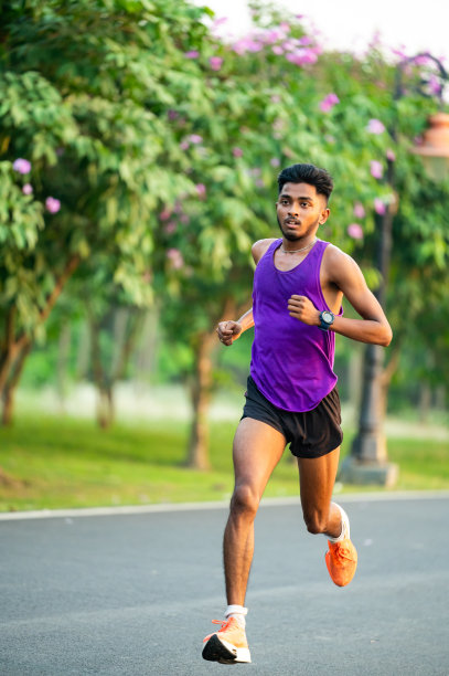年轻的亚洲运动员在水泥路上跑步，为马拉松训练。图片下载