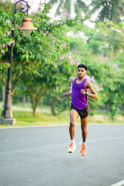 年轻的亚洲运动员在水泥路上跑步，为马拉松训练。图片下载