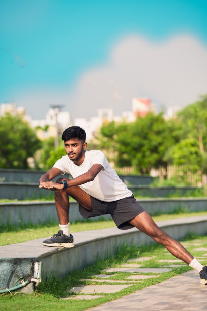 快乐的男运动员在公园的楼梯上练习弓步图片下载