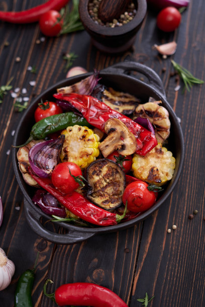 在家庭厨房的餐桌上用黑色陶瓷盘子烤蔬菜图片下载