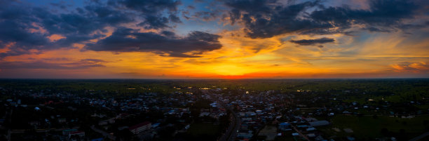 全景俯视图无人机在泰国村庄上空拍摄的航拍照片。顶视图美丽的日落与戏剧性的天空云。日出，乌云笼罩稻田。图片下载