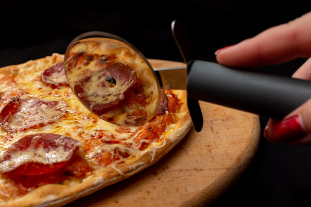 用特制的披萨刀切披萨图片下载
