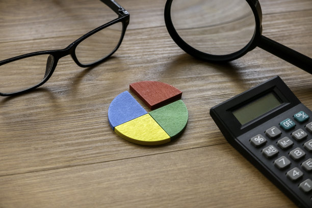 季度报告概念。公司财务报告。商业图表。彩色四分之一木制饼图件与计算器。图片下载