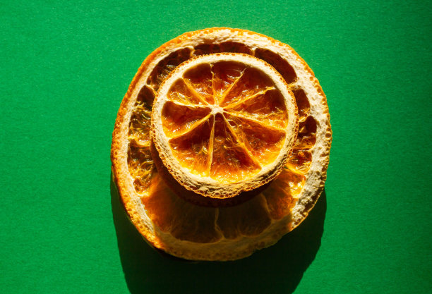 干橙片孤立的绿色背景图片下载